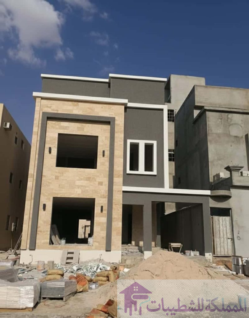 "أعمال تشطيب واجهة فيلا في حي ضاحية الملك فهد بالدمام، تدمج بين تكسيات الحجر الطبيعي والدهانات الرمادية، من تنفيذ معلم اصباغ وديكورات بالضاحية."
