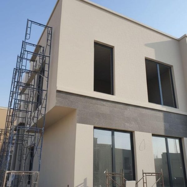 "تصميم واجهة فيلا مودرن بالدمام مقسومة لونين (بيج رملي ورمادي فاتح)، توضح فن تنسيق الاصباغ الخارجية والديكورات "