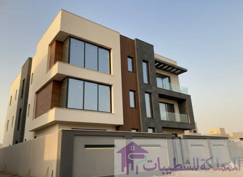 "تصميم واجهة فيلا مودرن في الدمام والخبر، تدمج بين دهانات البروفايل (لون رمادي وبيج) وديكورات بديل الخشب الطولية، تنفيذ معلم اصباغ خارجية محترف."