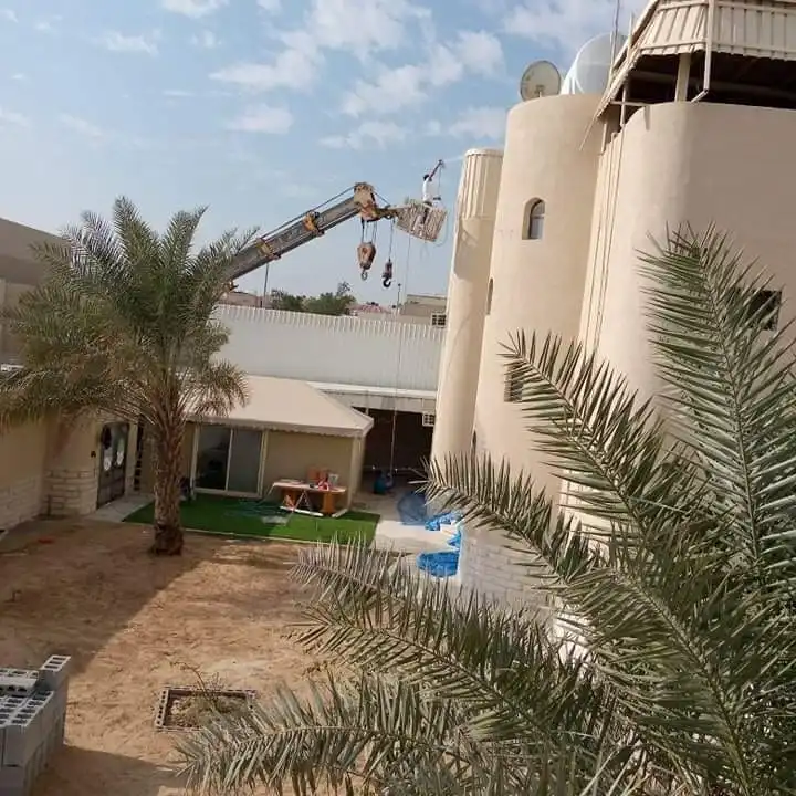 تنفيذ أعمال ترميم وتشطيب خارجي باستخدام ونش لرفع المعدات والعمل على واجهات مبنى سكني