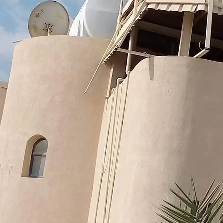 تشطيب وترميم واجهة خارجية لمبنى سكني بتصميم دائري مع دهانات خارجية مقاومة للعوامل الجوية