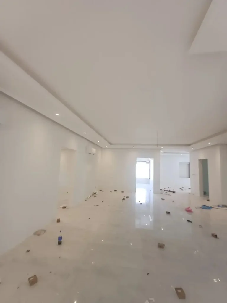 زاوية هندسية توضح إتقان أعمال تشطيب جبس بورد للأسقف وديكورات الجدران أثناء مراحل تشطيب غرف ومجالس الفيلا 