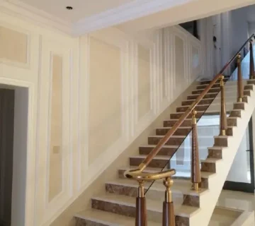 تصميم درج داخلي فاخر من الرخام والزجاج مع ديكورات جدران كلاسيكية (بانوهات) من تنفيذ مؤسسه تشطيبات محترفة 